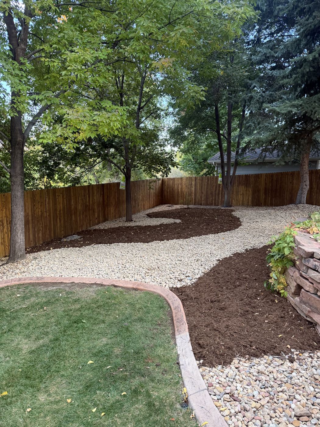 Backyard rock path with mulch beds and lawn edging