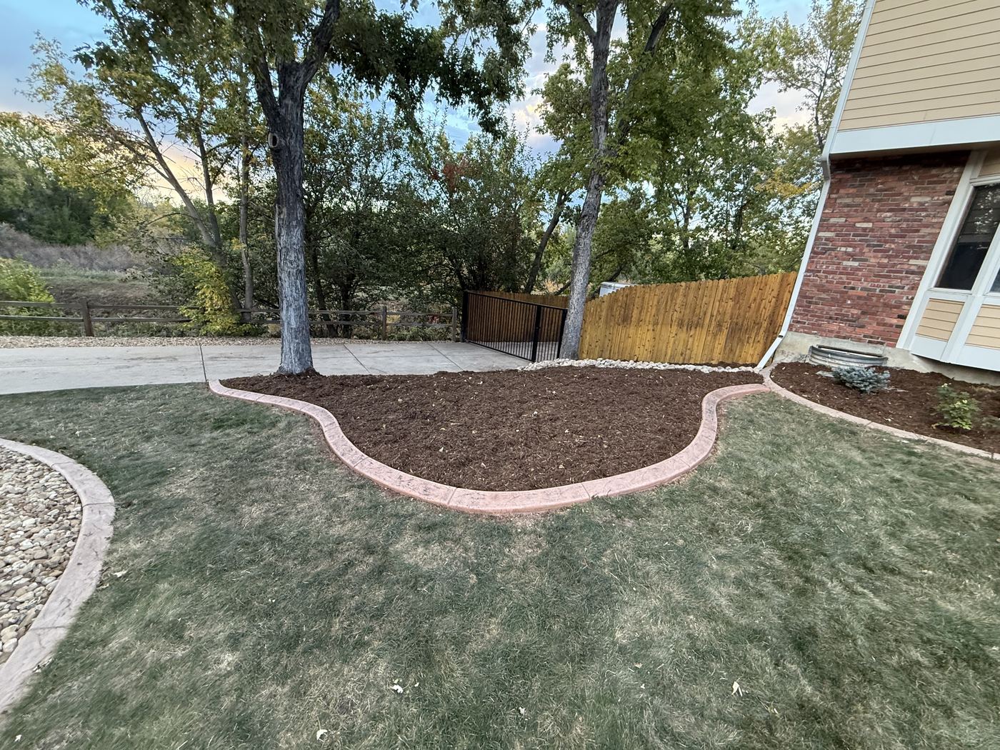 Curved mulch bed with stone edging